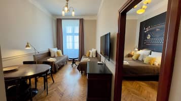 Una habitación de hotel con una cama, un escritorio, una silla, un televisor y una ventana con cortinas.
