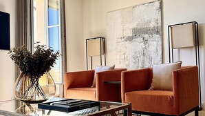 A modern living room with a sofa, coffee table, and a large abstract painting on the wall. - Mougins Luxury Retreats (Mougins)