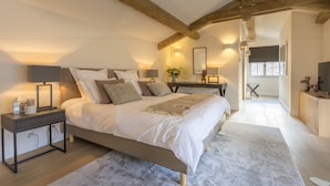 A bedroom with a large bed, bedside tables, and a wooden ceiling. - Mougins Luxury Retreats (Mougins)