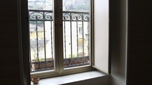 A room with a window overlooking a balcony with a wrought iron railing. - Gramsci Apartments (Naples)