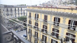 A multi-story building with balconies and a street view. - Gramsci Apartments (Naples)