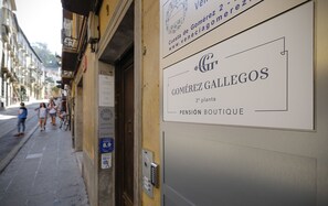 Un immeuble avec une enseigne indiquant « Gomérez Gallegos » et « Pensión Boutique ».