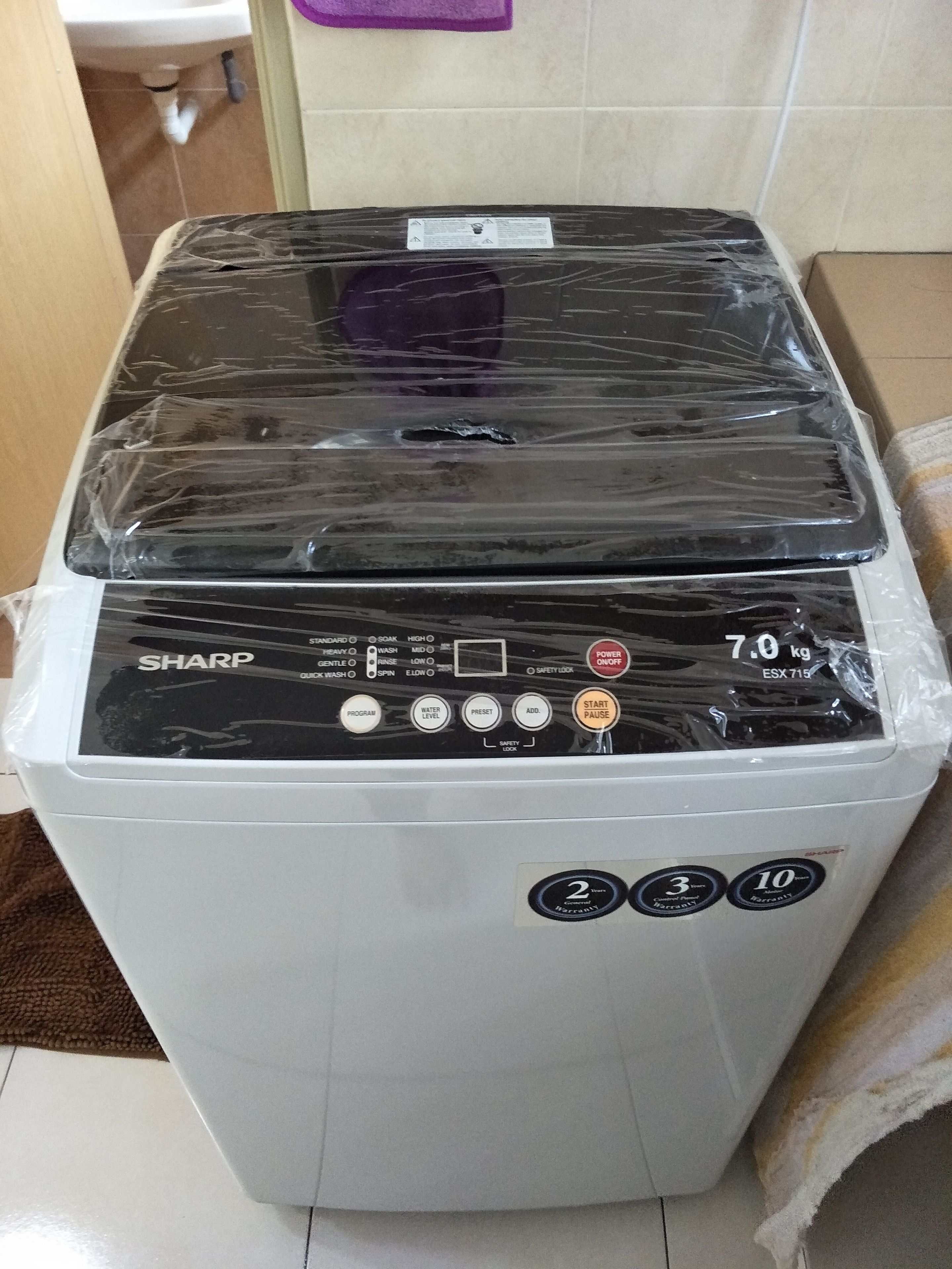A white washing machine with a black control panel, a weight capacity of 7.0 kg, and a 2-year warranty.