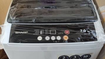 A white washing machine with a black control panel, a weight capacity of 7.0 kg, and a 2-year warranty.