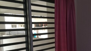Een kamer met een schuifdeur van glas die leidt naar een balkon.