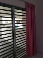 Quarto com porta de vidro deslizante que dá para uma varanda externa.