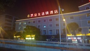 A hotel with a prominent red sign and multiple windows.