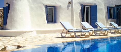 Alberca al aire libre y camastros