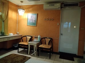 A compact kitchen with a dining area, featuring a refrigerator, a sink, and a small table with chairs.