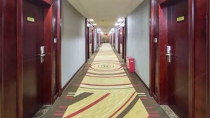 A hotel hallway with wooden doors, numbered room signs, and a patterned carpet. - Kaiserdom Changsha South Station (Changsha)