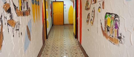 A hallway with colorful wall art and a patterned floor.