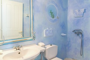 A bathroom with a white sink, a toilet, and a shower. - Cavo Nano (Mykonos)