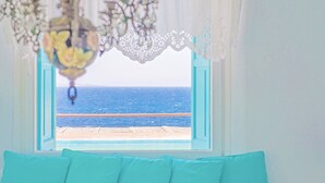 A room with a view of the sea through a window with a white lace curtain. - Cavo Nano (Mykonos)