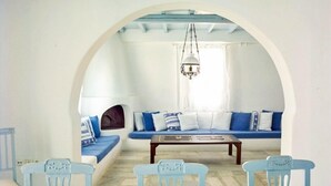 Una habitación con una decoración en blanco y azul, que incluye un sofá, una mesa de centro y sillas azul claro.