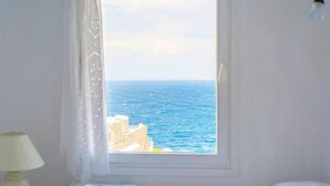 Una habitación con una cama, una ventana y una lámpara.