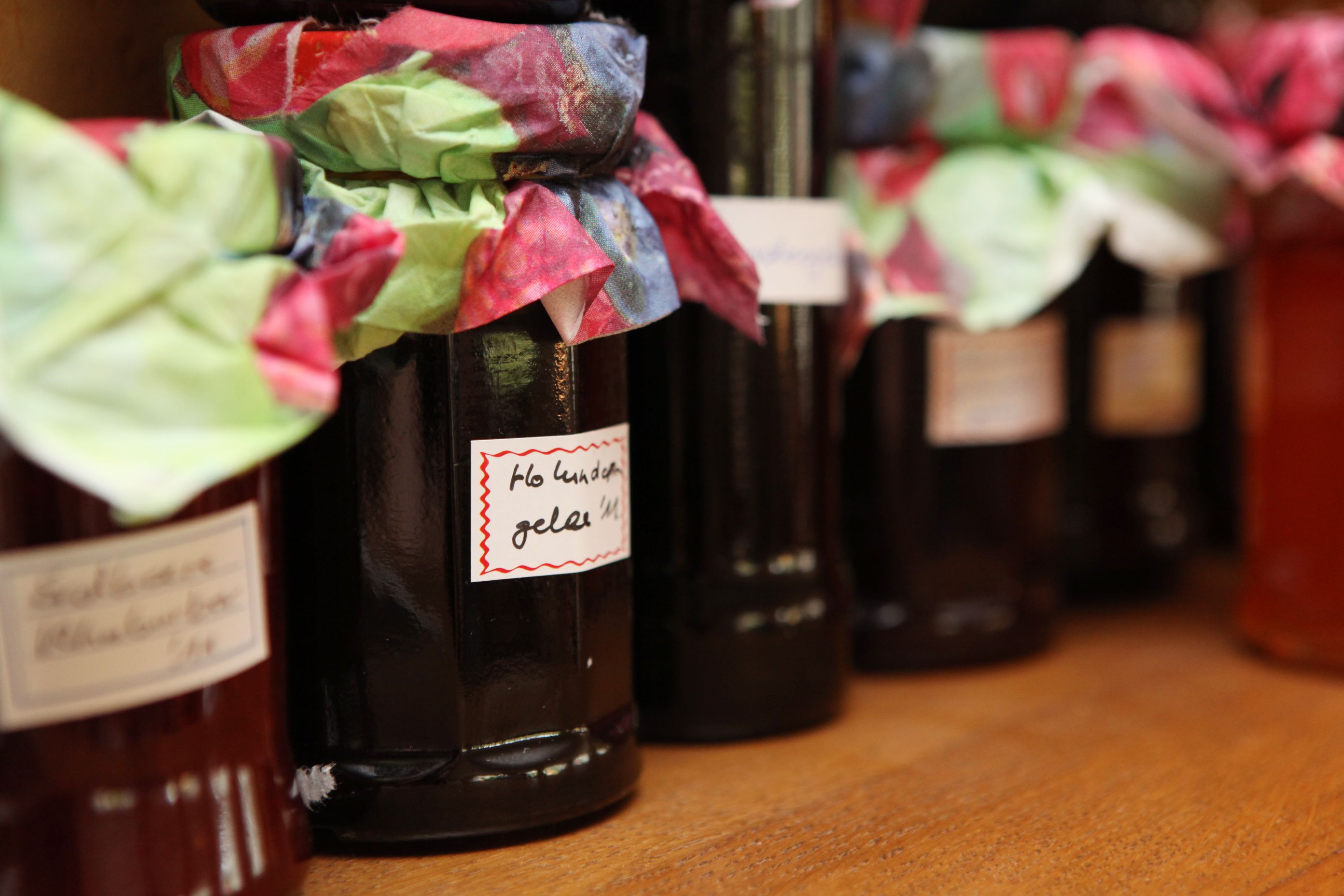 Varias botellas con etiquetas, algunas envueltas en papel de colores.