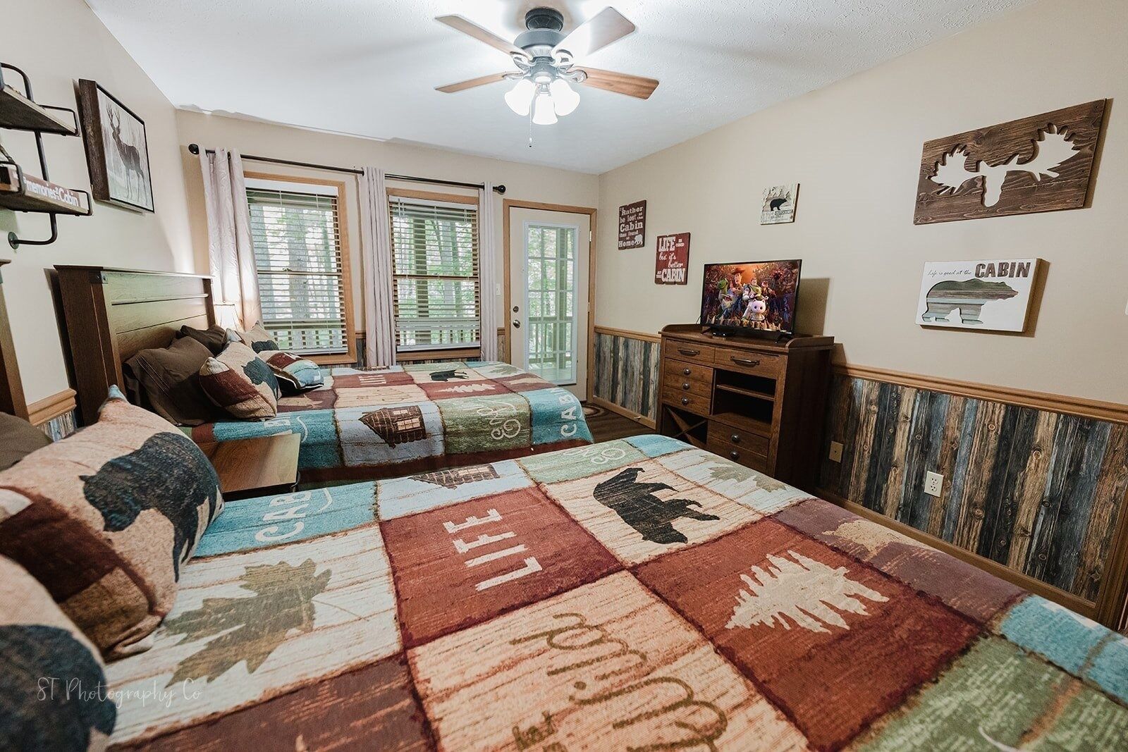 Een knus slaapkamer in chaletstijl, met een groot bed, een dressoir en een televisie.