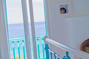A view from a window overlooking the sea with a balcony railing. - Cavo Delos (Mykonos)