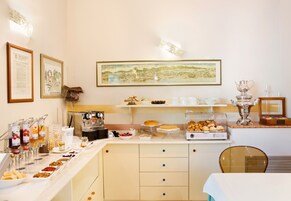 Un buffet ricco di cibi e una macchina per il caffè.