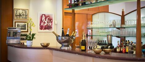 A bar area with a variety of liquor bottles, glasses, and a coffee machine.