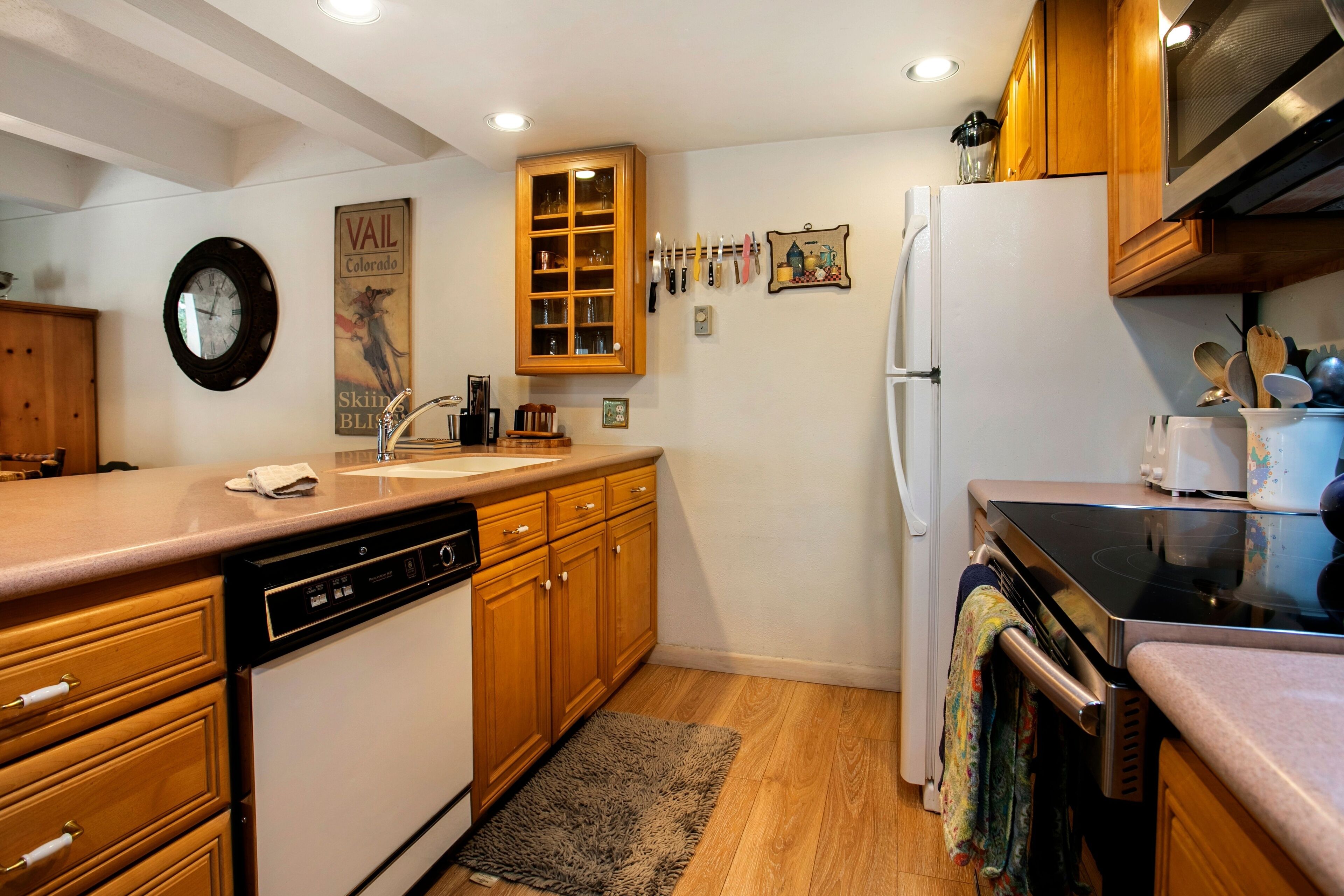 A kitchen with wooden cabinets, a dishwasher, a refrigerator, and a microwave.