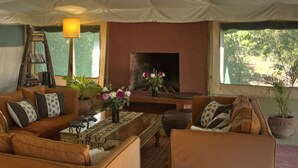 Una sala de estar acogedora con un conjunto de sofás, una mesa de centro, una estantería y una chimenea.