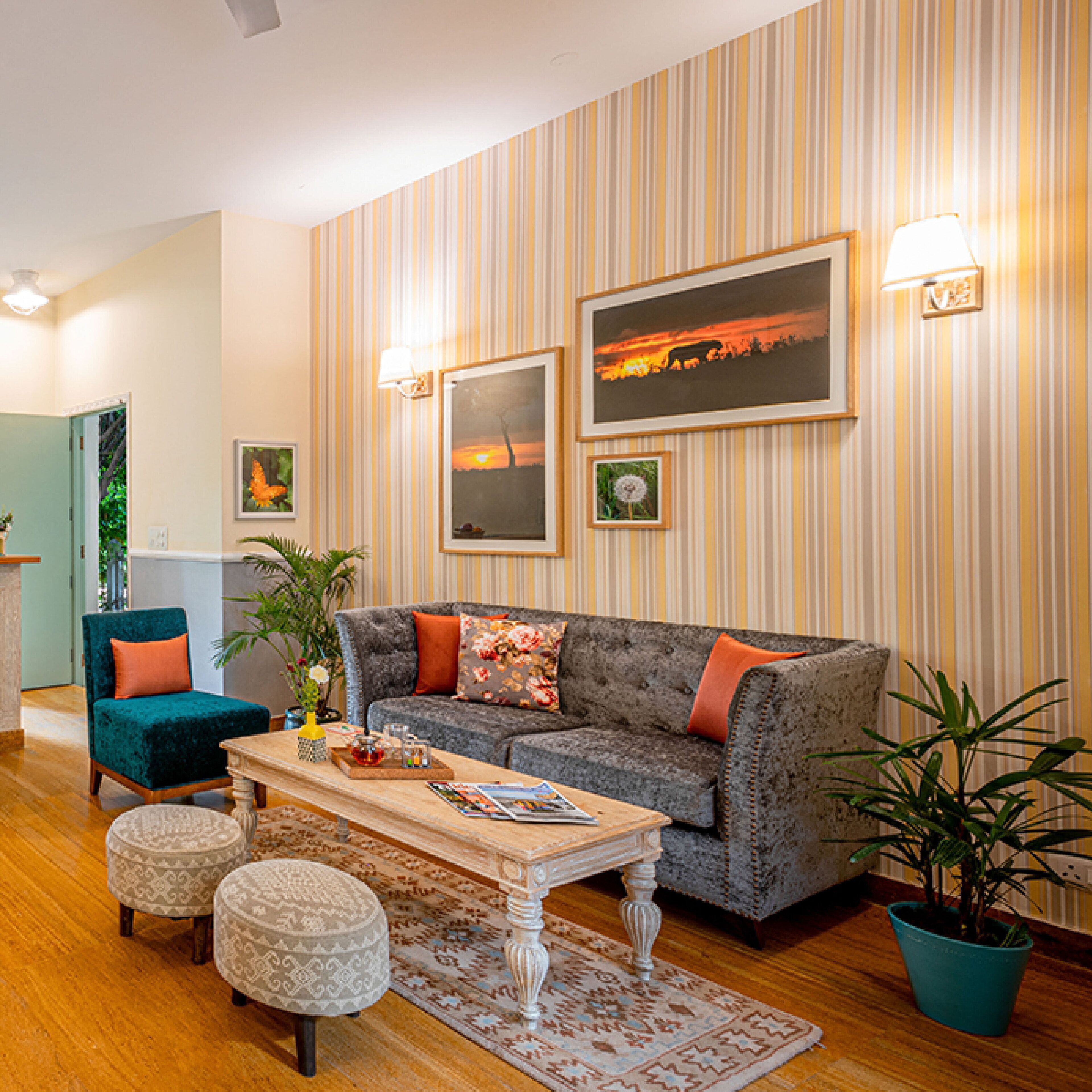 Ein Wohnzimmer mit Sofa, Poufs, einem Couchtisch und einer Zimmerpflanze.