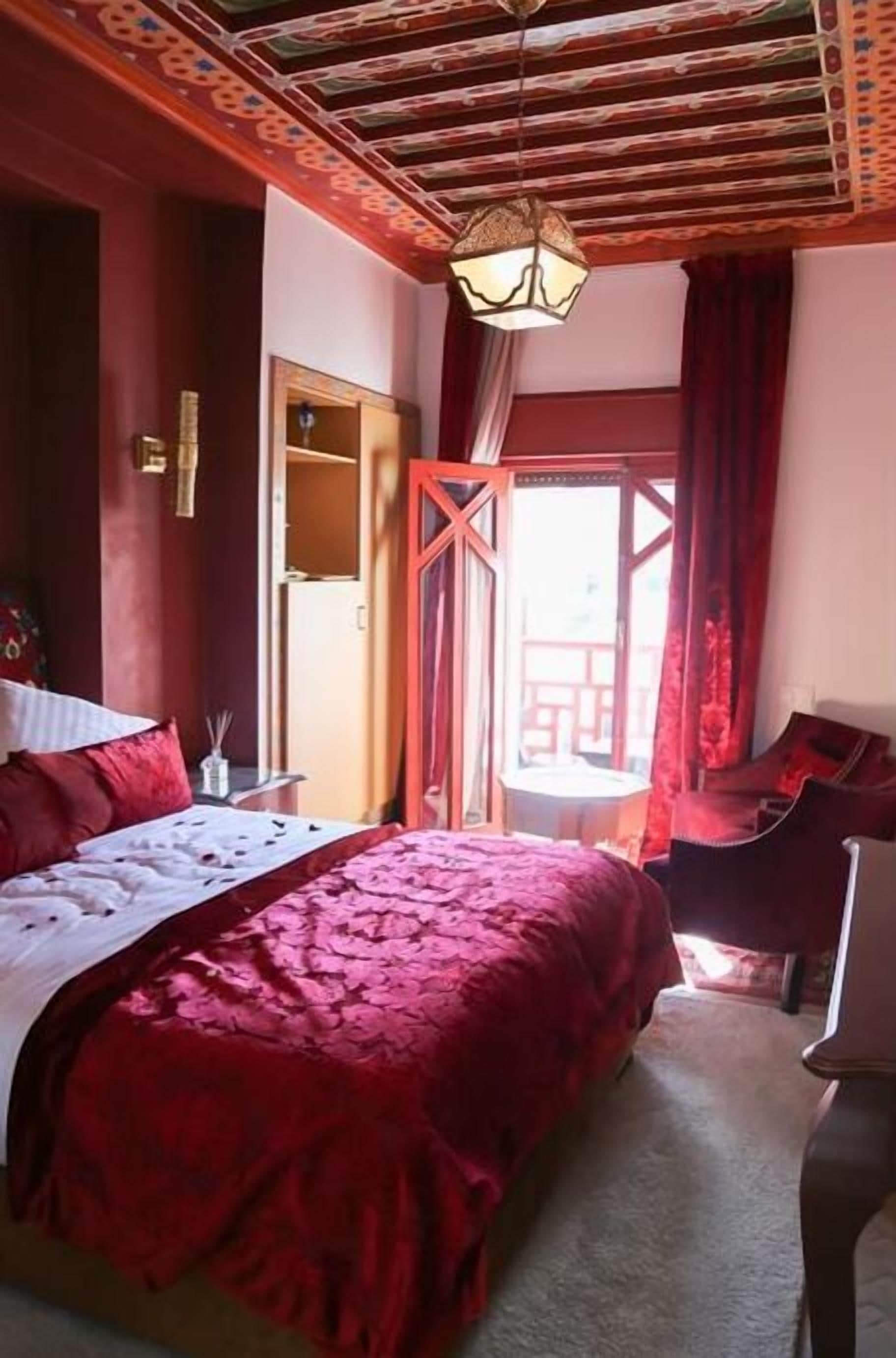 Un dormitorio con una cama grande, techo de madera y vistas al exterior.