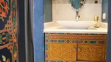 Un baño con lavamanos, azulejos decorativos y un mueble con diseño.