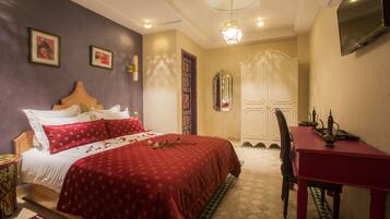 Habitación de hotel con una cama grande, un escritorio y un armario.
