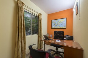 A small office with a desk, chair, laptop, and a world map on the wall.