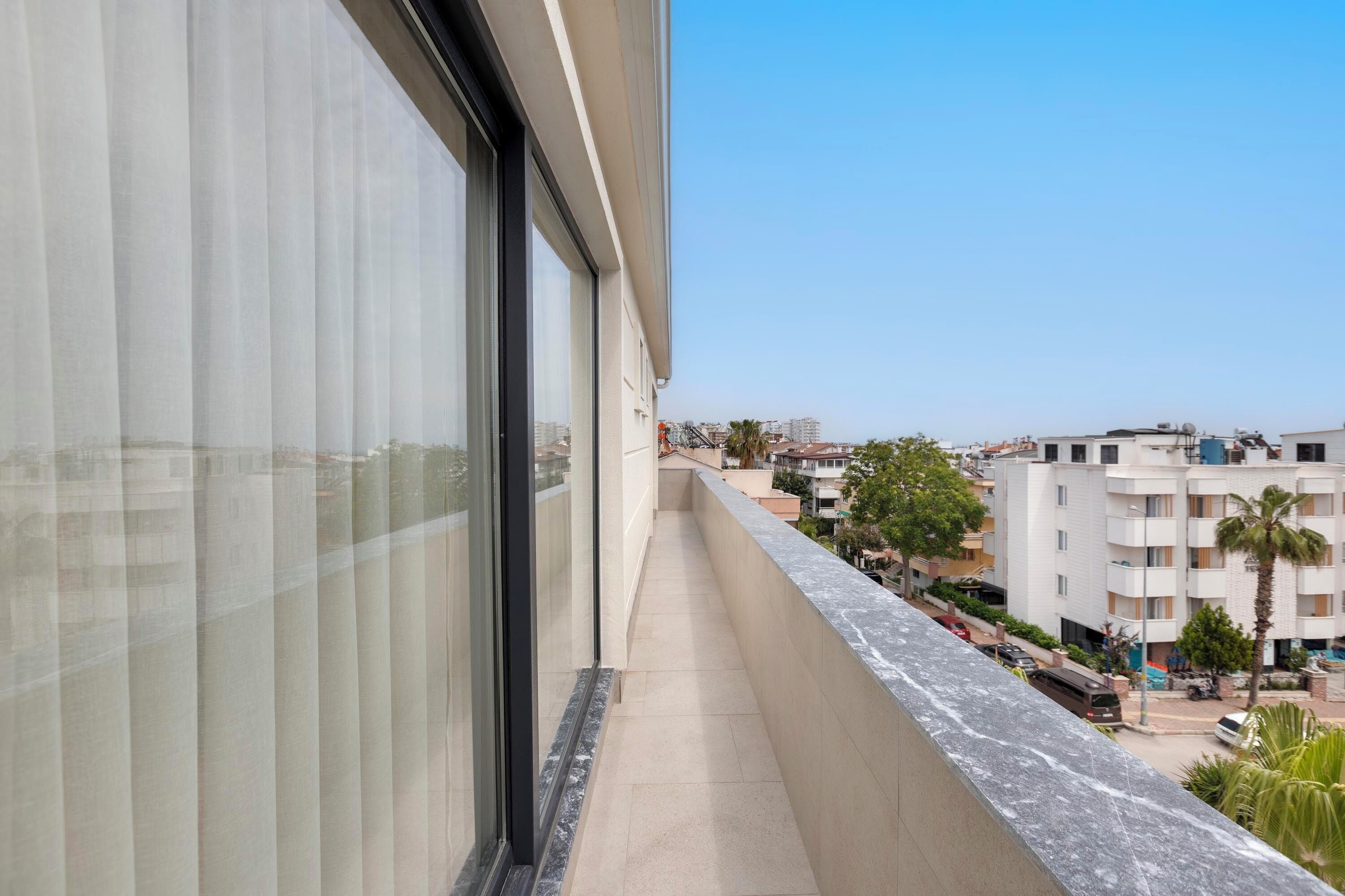 Een balkon met een helder uitzicht op de omliggende gebouwen en de straat.