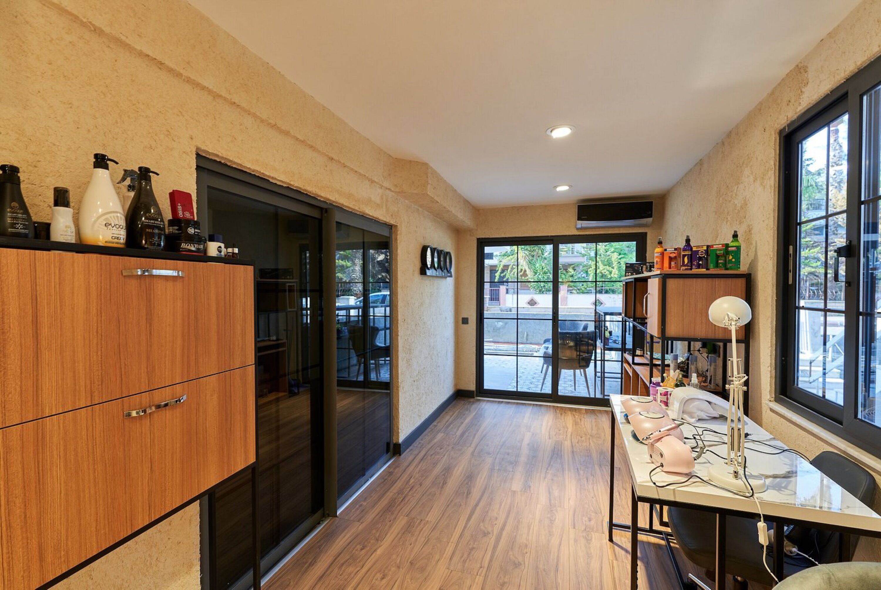 Una cocina moderna con armarios de madera, una encimera con varias botellas y un comedor con mesa y sillas.