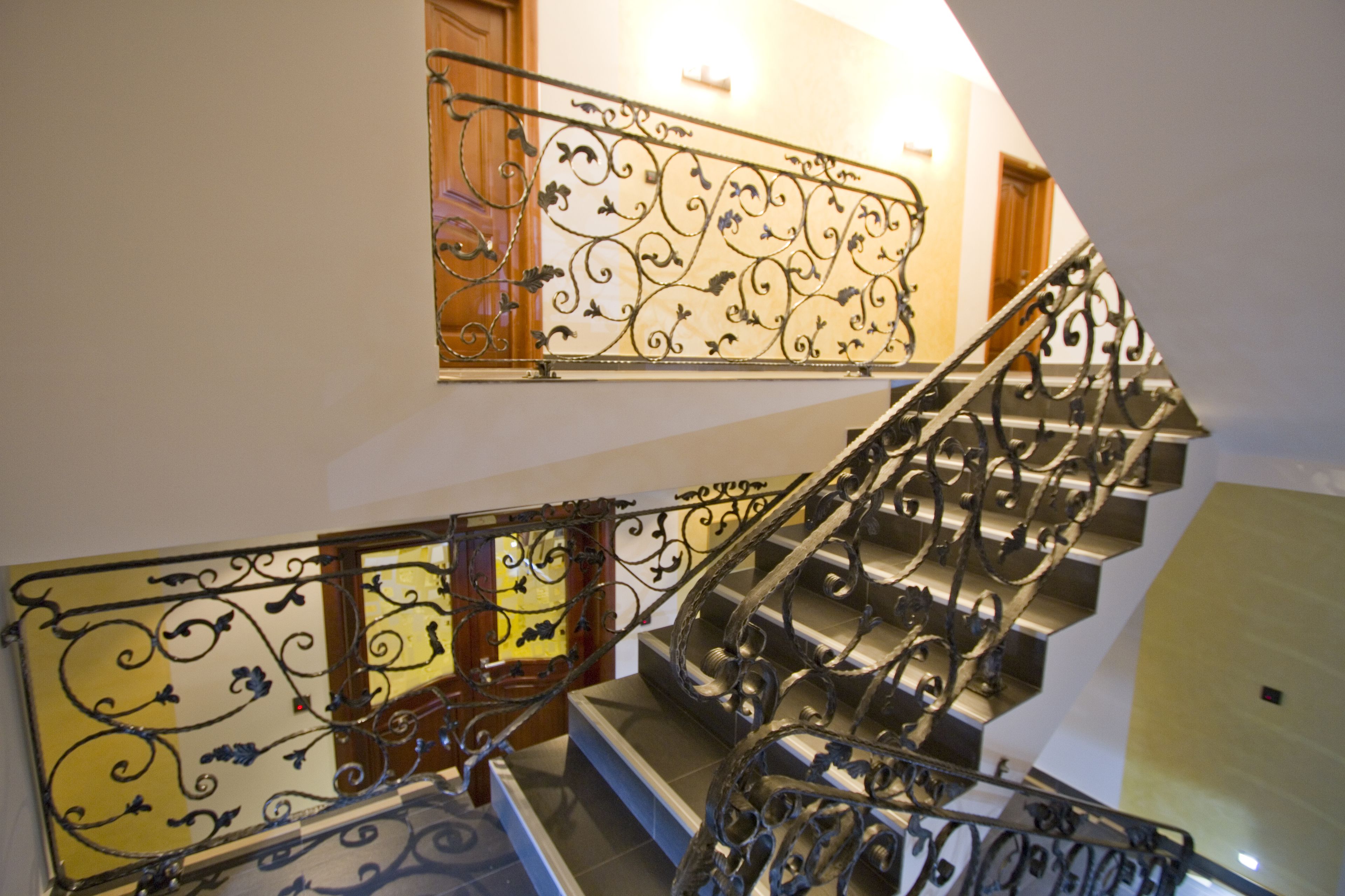 A staircase with ornate metal railings and wooden steps.