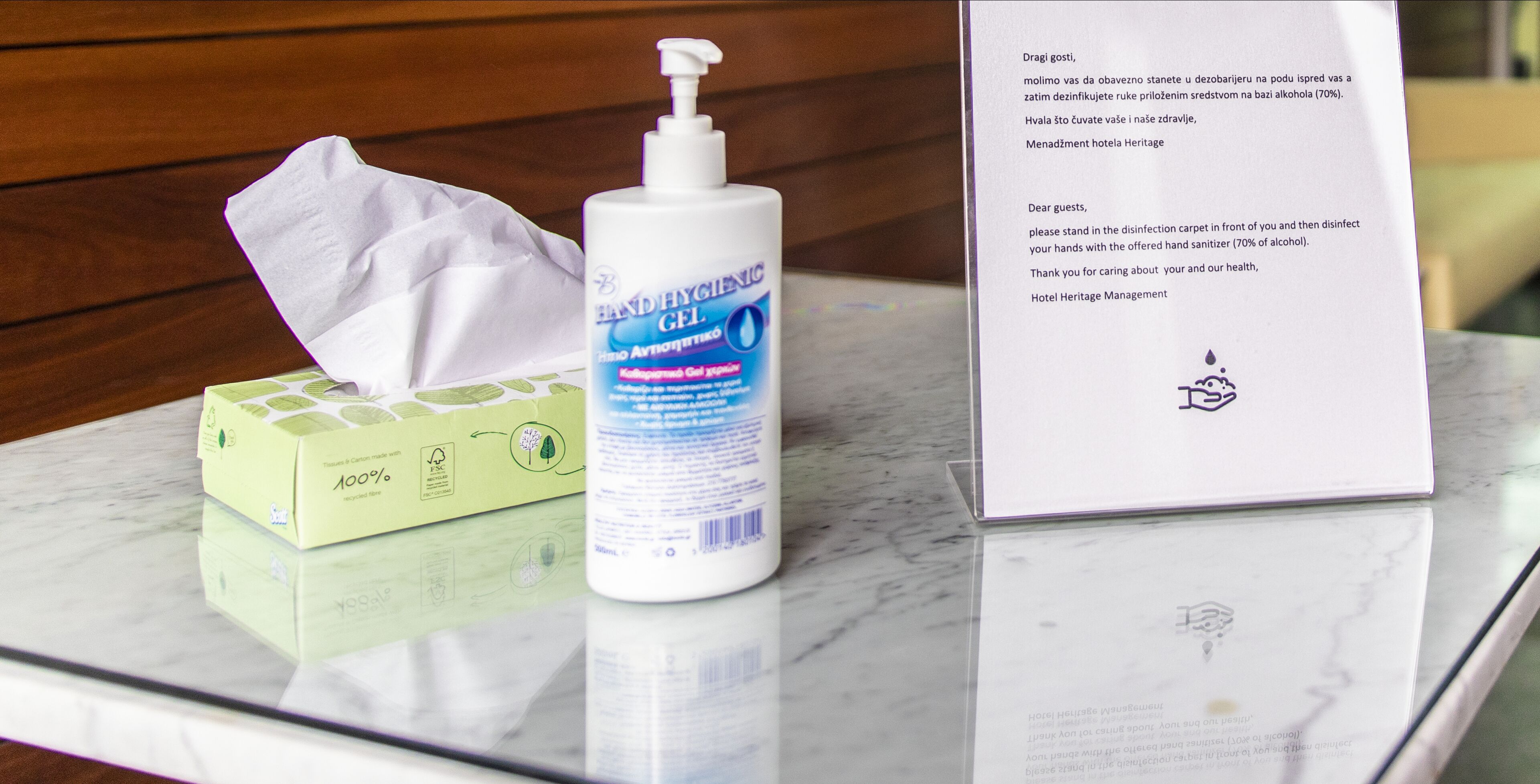 Un punto per l'igiene delle mani con fazzoletti, gel disinfettante e un cartello.