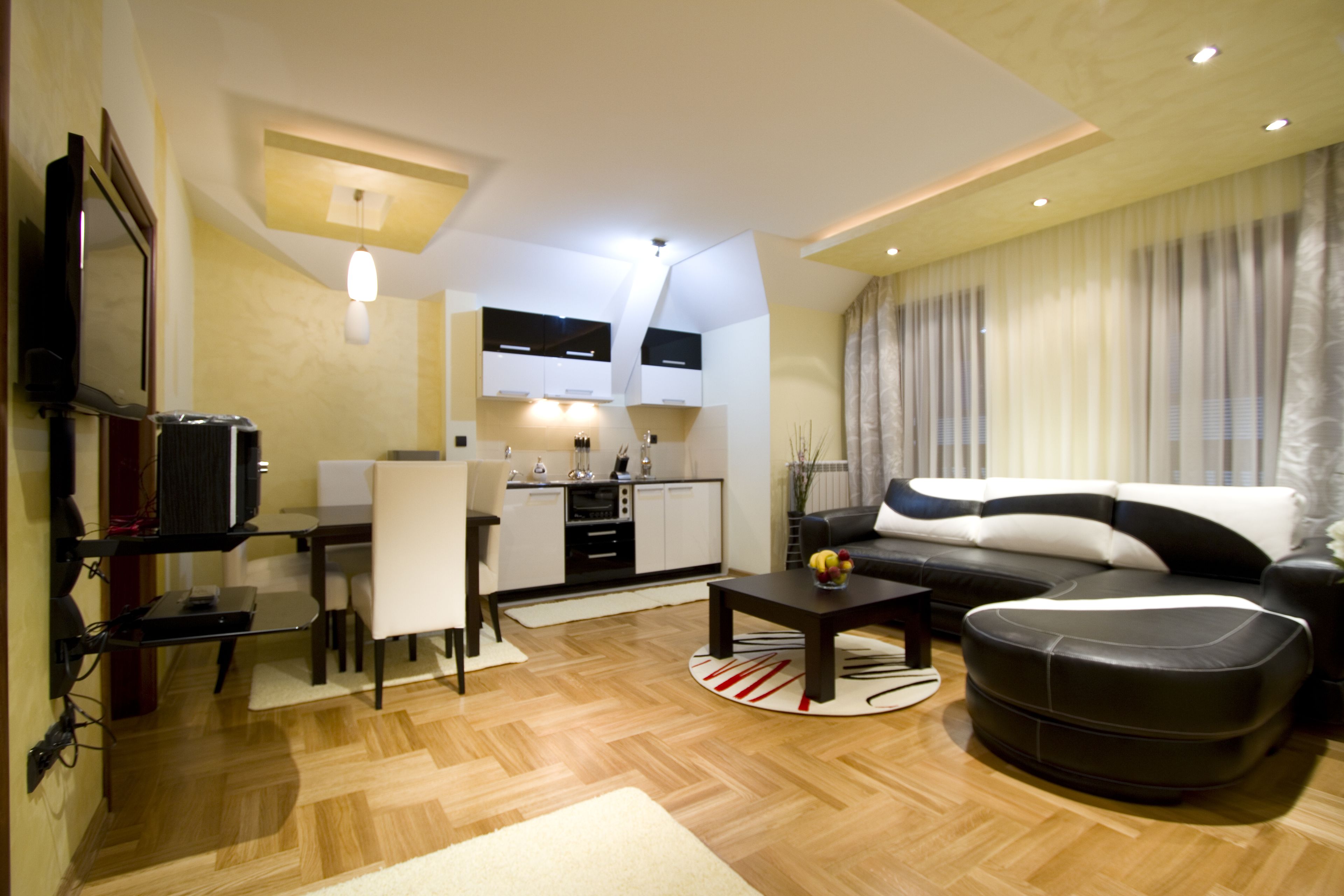 A modern living room with a sofa, coffee table, and dining area.