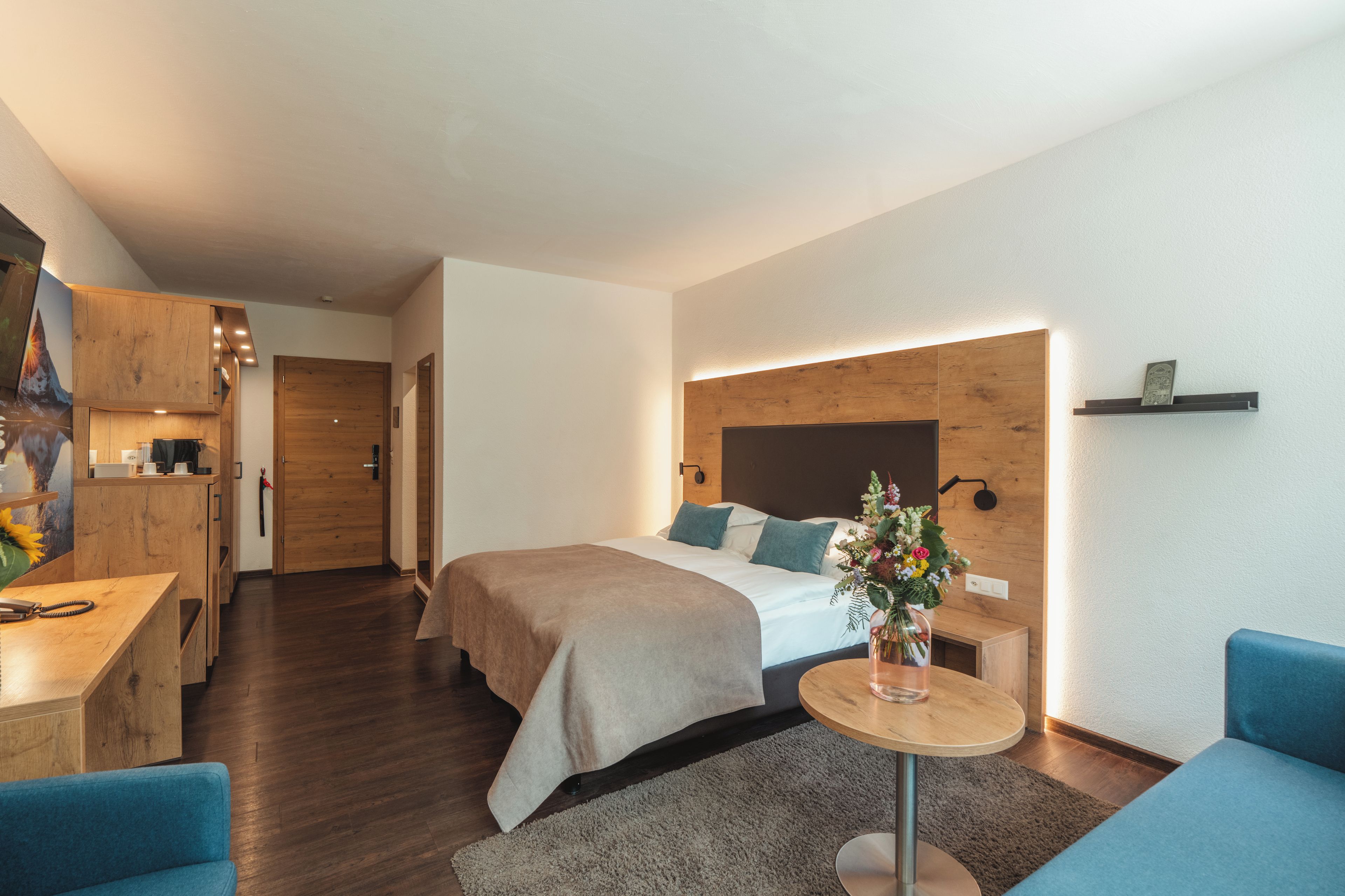 Una habitación de hotel moderna con cama, escritorio y kitchenette.