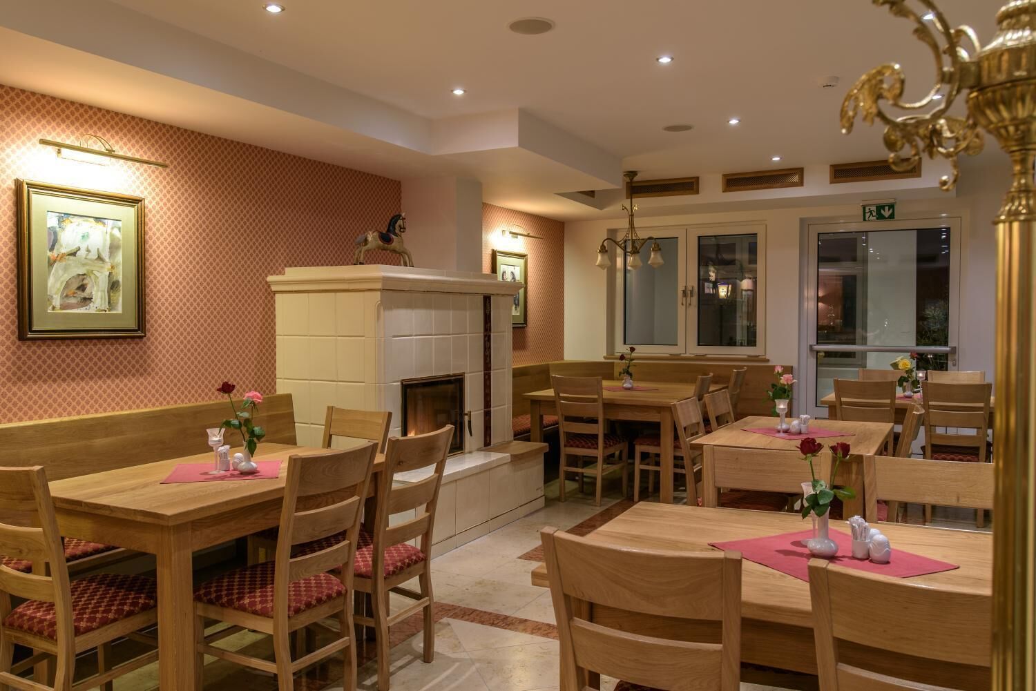 Un restaurante con mesas y sillas de madera, una chimenea y cuadros en las paredes.