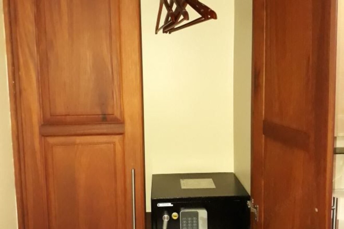 A room with wooden doors, a small black appliance on a black countertop, and a wall-mounted triangular decoration.