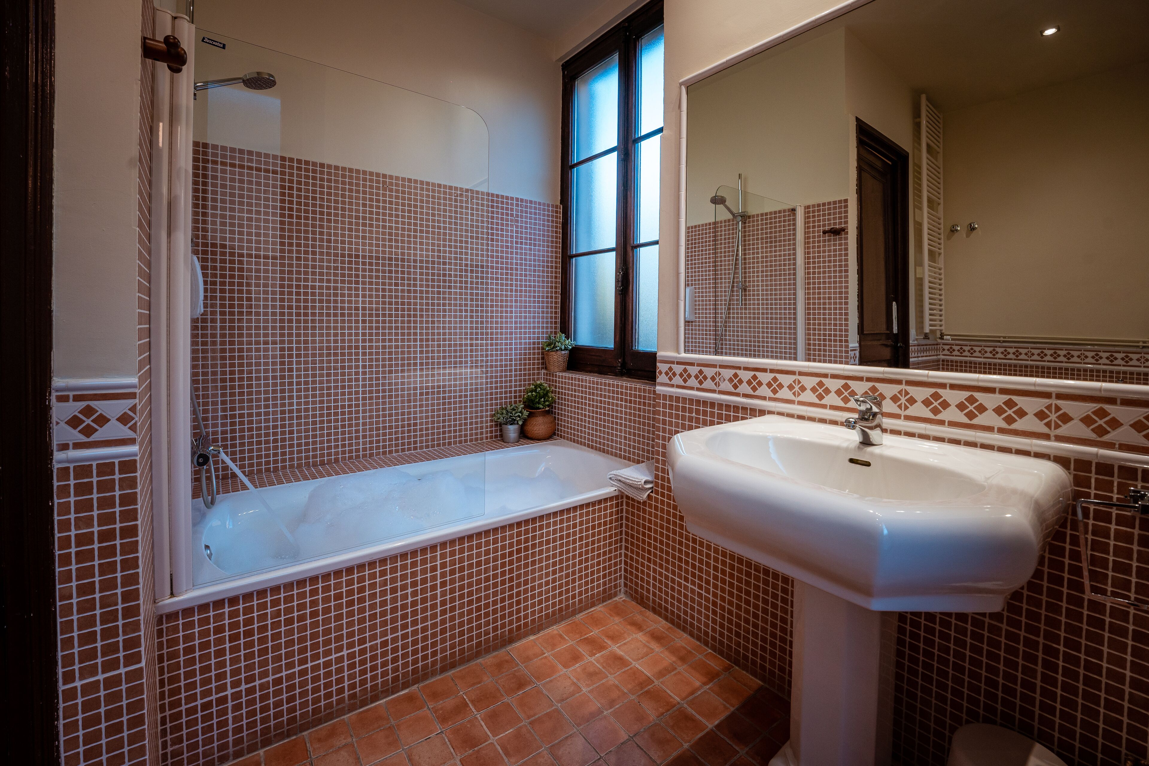 Un baño con bañera, lavamanos y ventana.