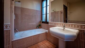 Un baño con bañera, lavamanos y ventana.