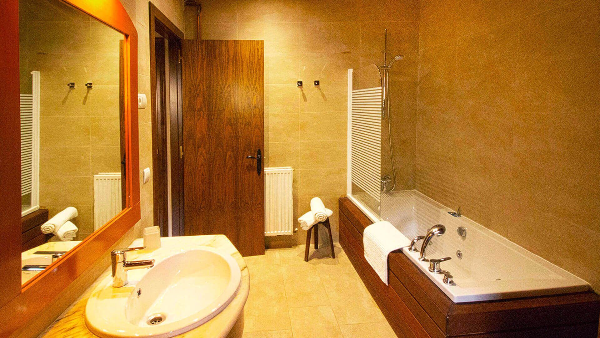 A bathroom with a sink, mirror, towel rack, and a bathtub.