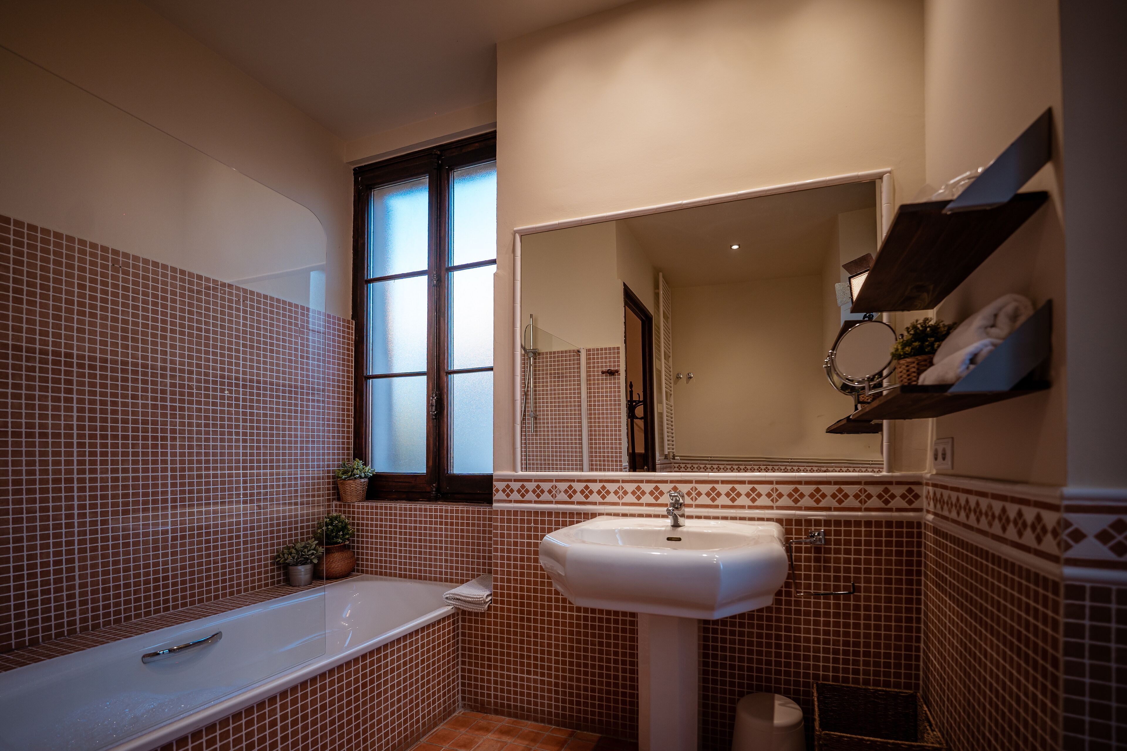 Un baño con bañera, lavabo y espejo.