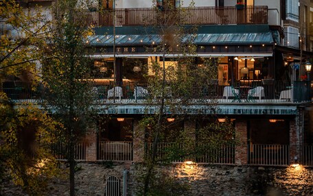 A two-story building with a balcony and a covered outdoor seating area.