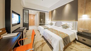 Una habitación de hotel con dos camas, un escritorio, un televisor y una zona de estar.