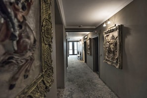 A hallway with ornate wall decorations and a carpeted floor.