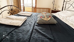 Un dormitorio con cama, almohadas, mesita de noche y lámpara.