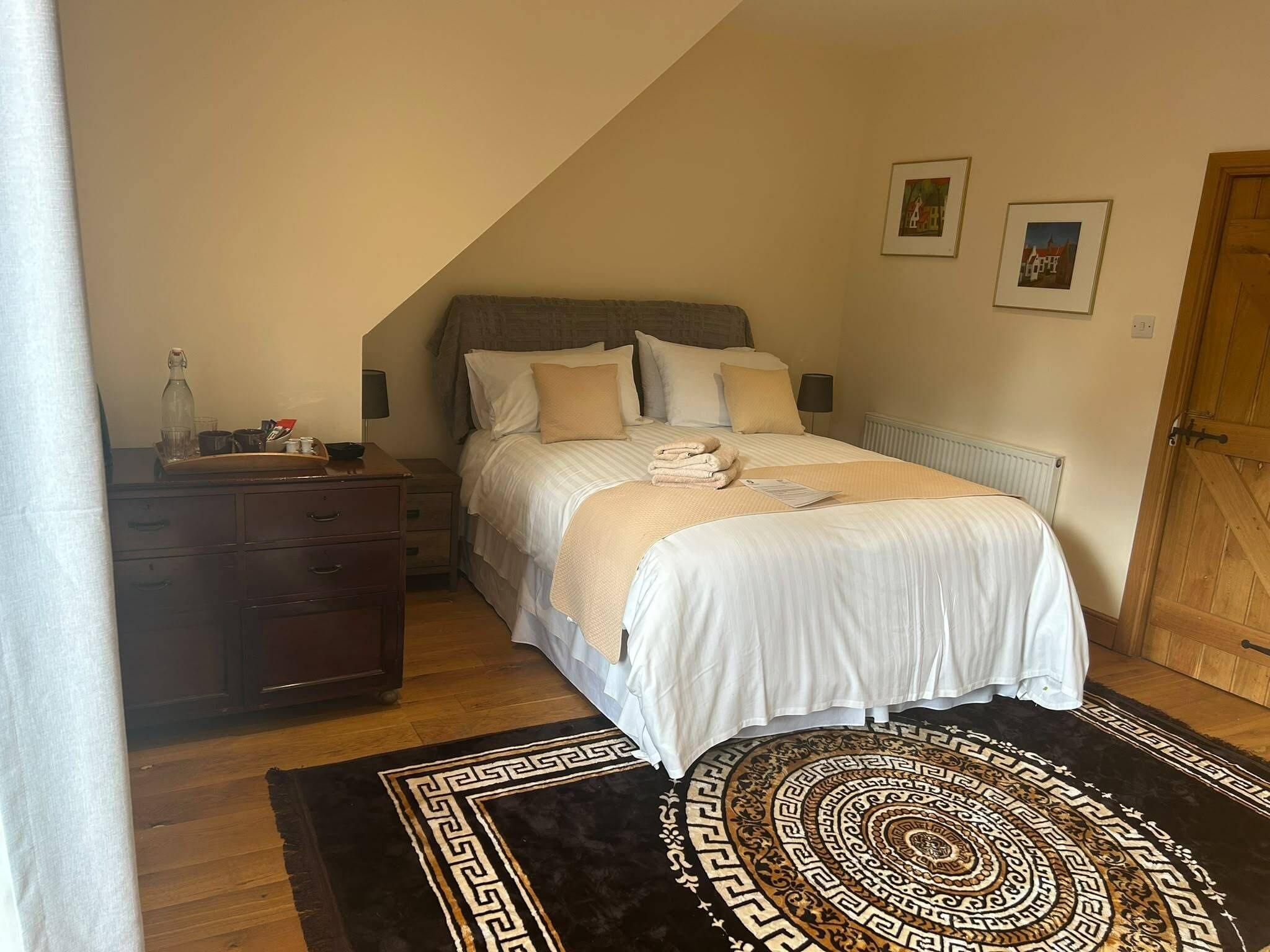 Ein Schlafzimmer mit einem Bett, einem Schminktisch, einem Heizkörper und einer Tür.