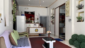 Una sala de estar con sofá, una mesa de centro y una cocina al fondo.