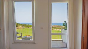 Una habitación con vistas a un paisaje verde y un balcón.
